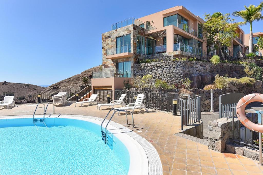 a villa with a swimming pool and a house at Los Lagos 36 by VillaGranCanaria in Las Palmas de Gran Canaria