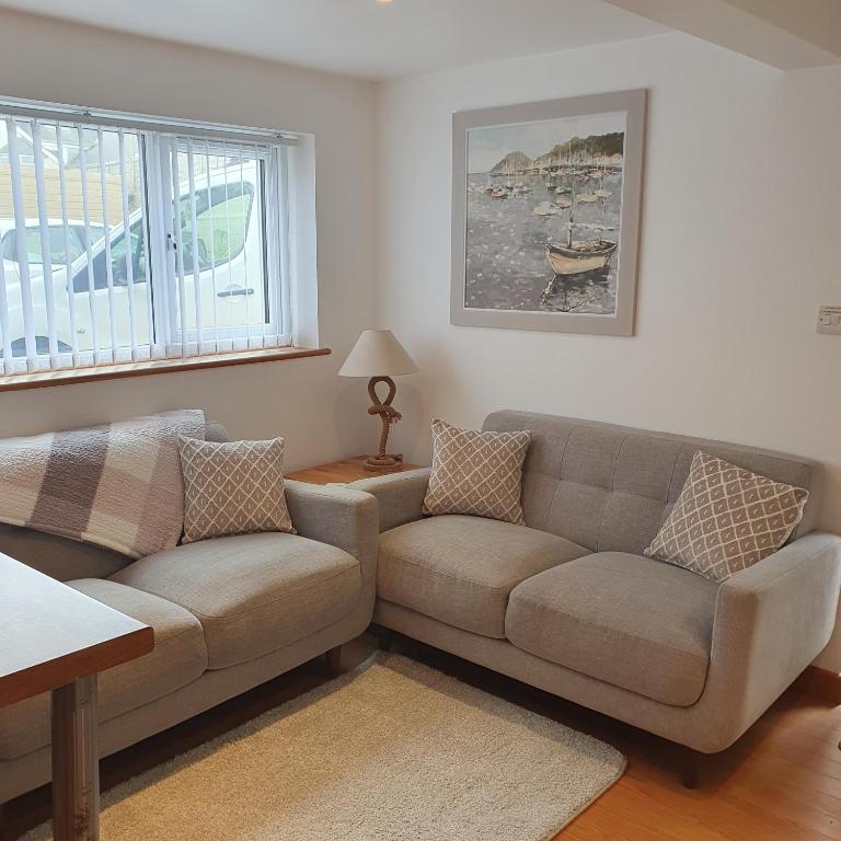 a living room with a couch and a table at Chynoweth Mews in Newquay