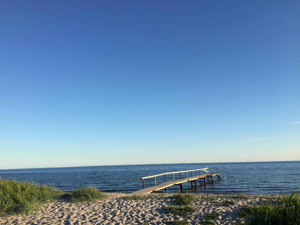 a dock on a beach next to the ocean at Funen Cottage With Fantastic Sea View, in Assens