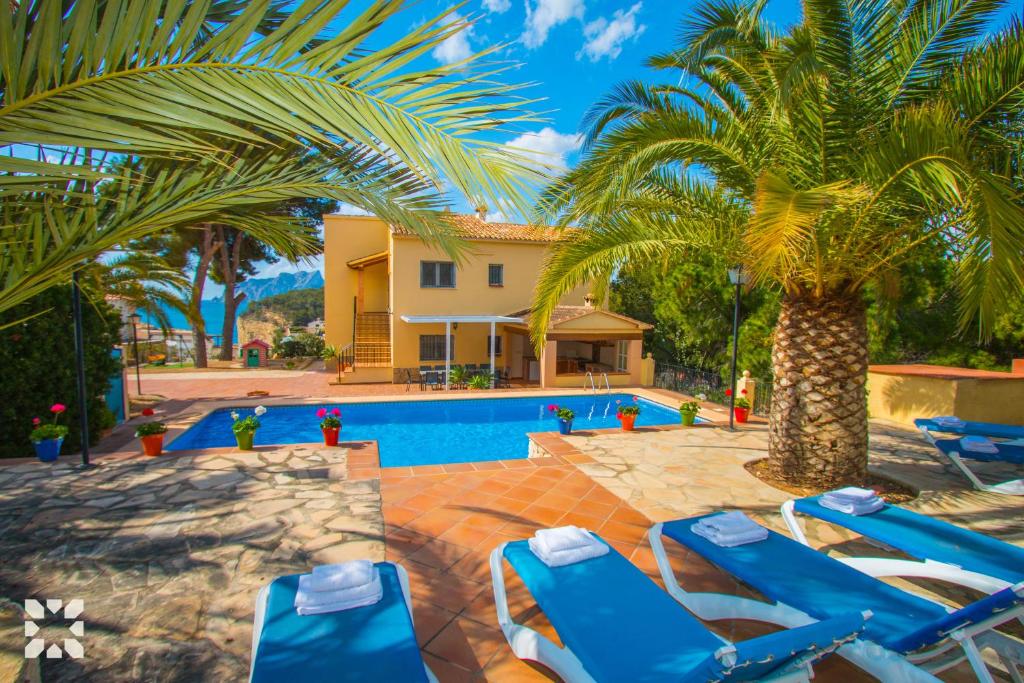 a villa with a swimming pool and palm trees at Villa Paula by Abahana Villas in Benissa