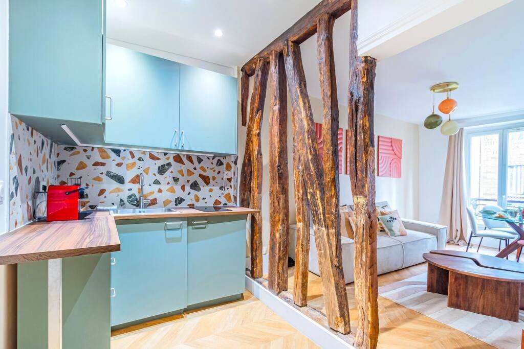 eine Küche mit blauen Schränken und ein Wohnzimmer in der Unterkunft Appartement design invalides bon marché - V in Paris