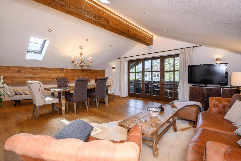een woonkamer met een bank en een tafel bij Chalet Vierjahreszeiten in Garmisch-Partenkirchen