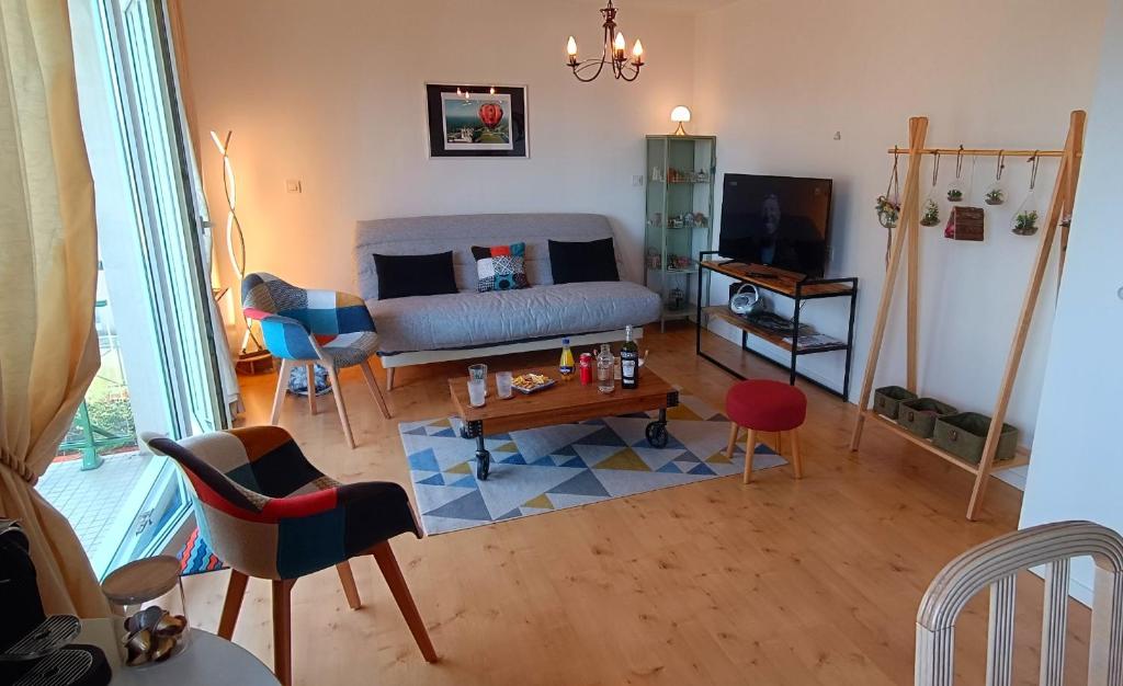 un salon avec un canapé et une table dans l'établissement À 8 min à pieds de la plage, du centre ville et du Brittany Ferries, à Ouistreham