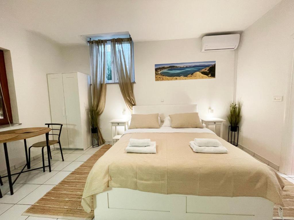 a bedroom with a bed with two towels on it at Basement Studio Bed&Breakfast in Punat