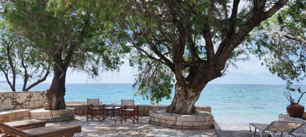 a table and chairs and trees on the beach at House On The Wave in Marathokampos