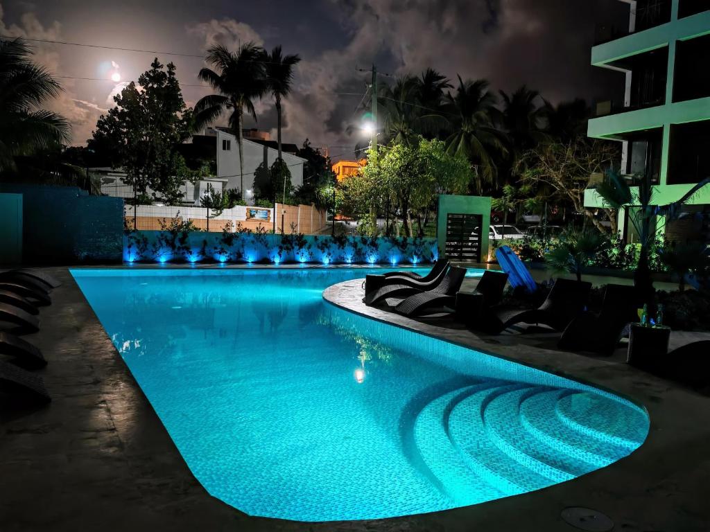 una piscina por la noche con luces azules en Surf One, en Sosúa