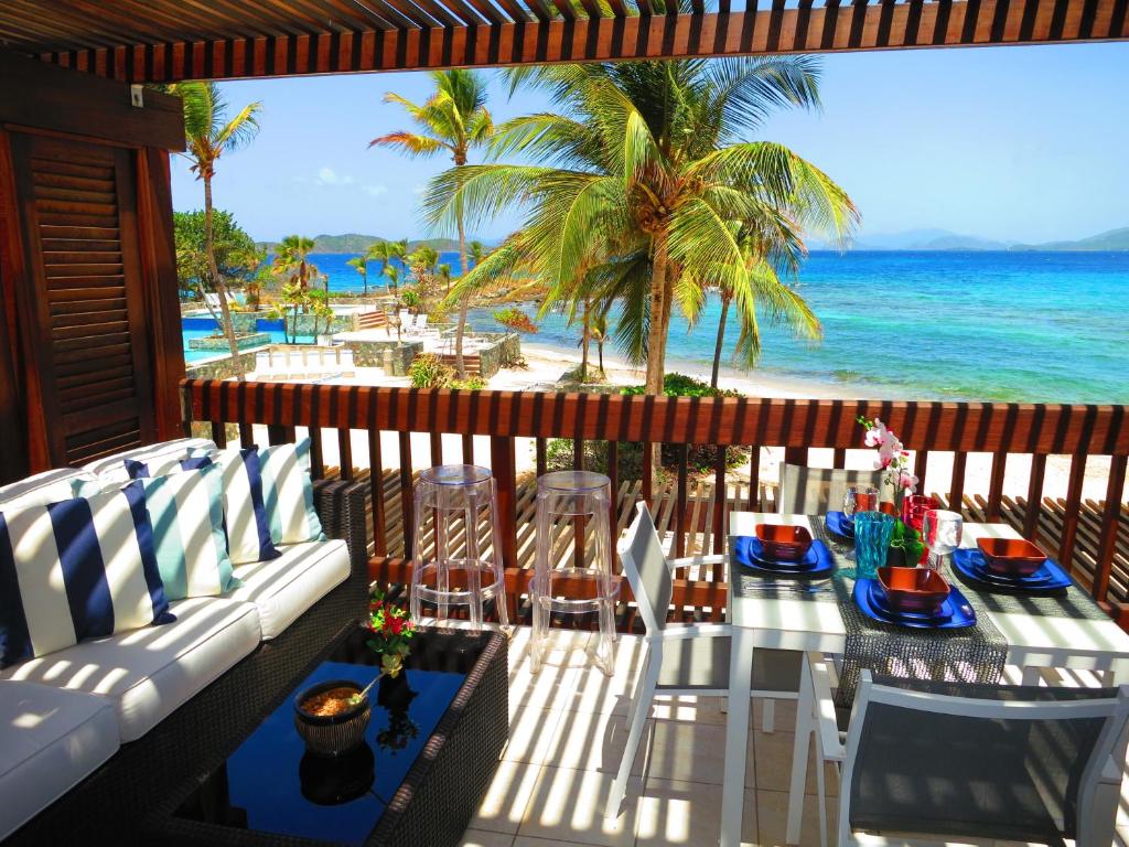 a patio with a table and chairs on the beach at Luxury Beachfront King Suite on Sapphire Beach II in East End
