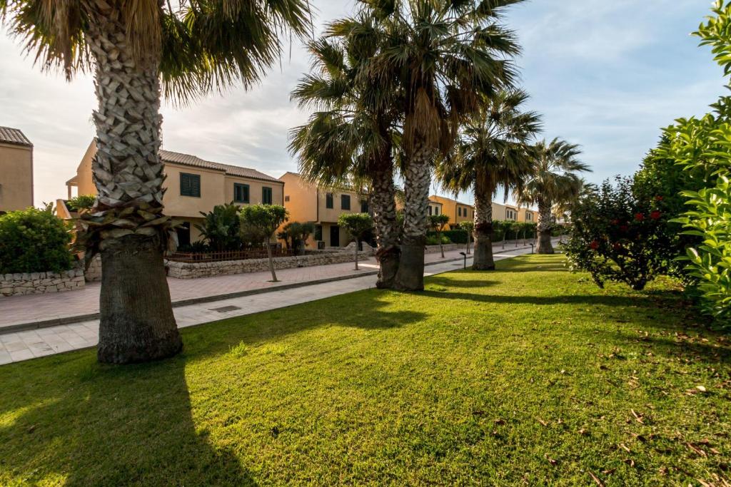 a row of palm trees in a park at Residence Andrea Doria in Marina di Ragusa