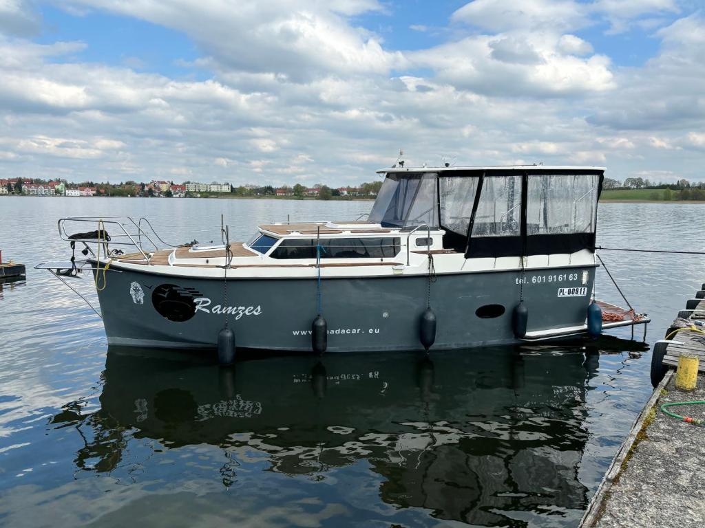 una barca è ormeggiata in acqua di Jacht motorowy Calipso 750 a Ryn