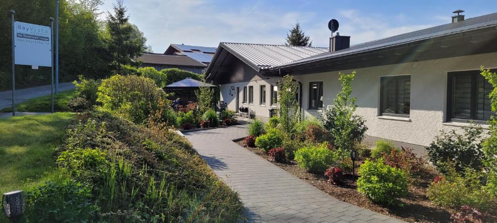 une maison avec une passerelle à côté d'un bâtiment dans l'établissement BayVista, die Bayerwald Lodge, à Lam