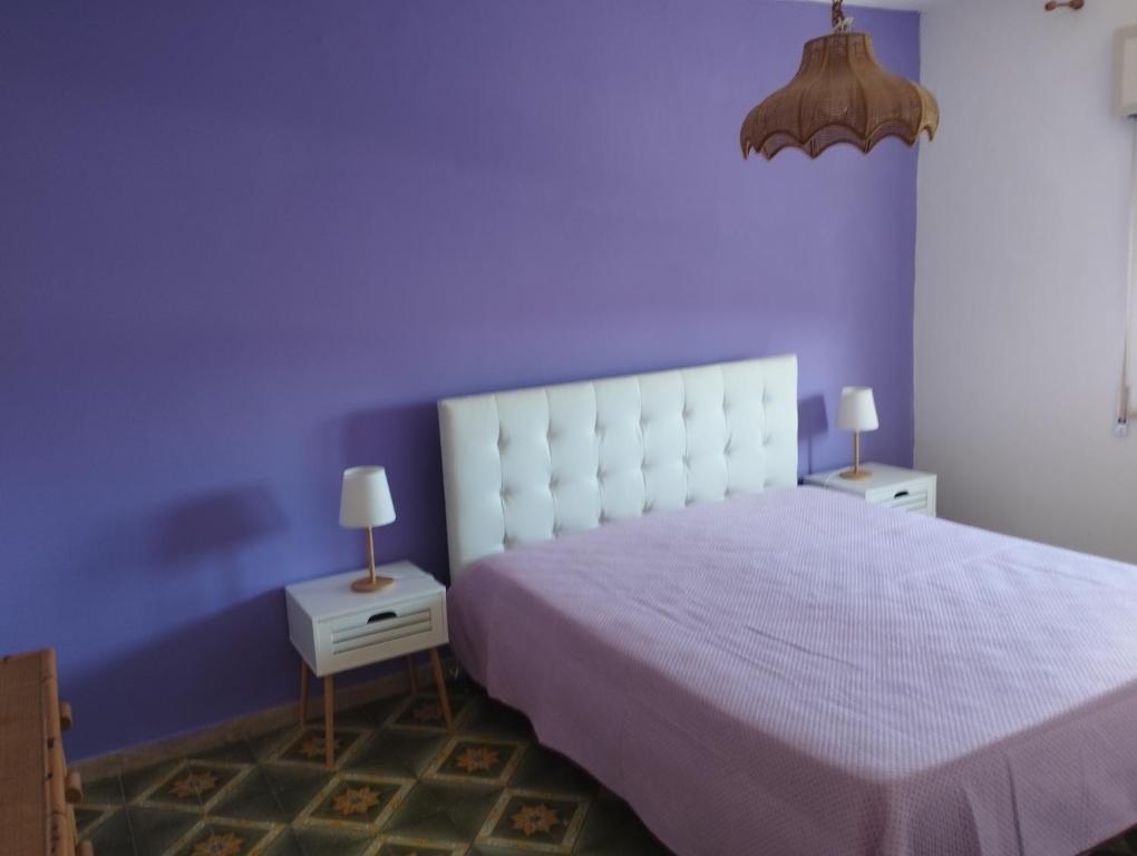 1 dormitorio púrpura con 1 cama y 2 mesitas de noche en Finestra sul mare, en Erice