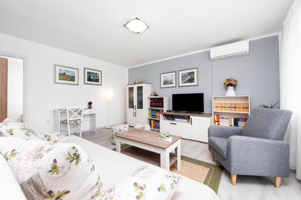 a living room with a couch and a chair and a table at Apartman Oly in Rovinj