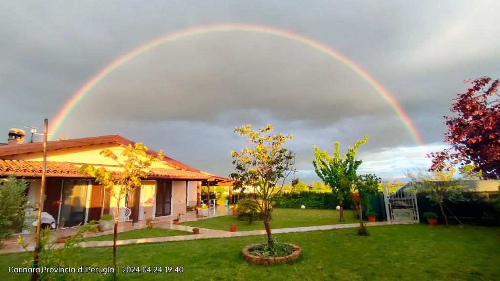Un arcobaleno nel cielo sopra una casa di A CASA DI DEBY GREEN HOUSE a Limigiano