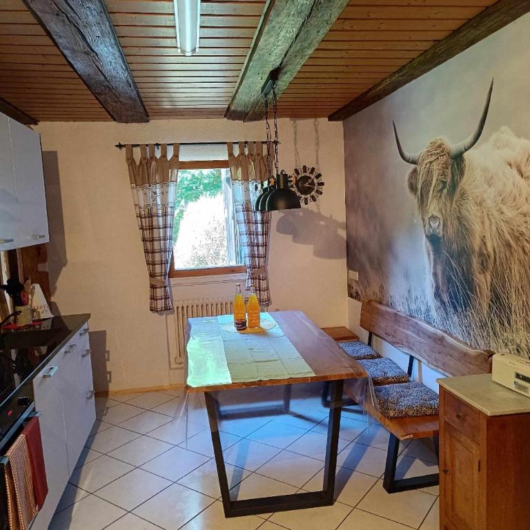 una cocina con una mesa con una foto de un toro en la pared en Am Rubach, en Baden-Baden