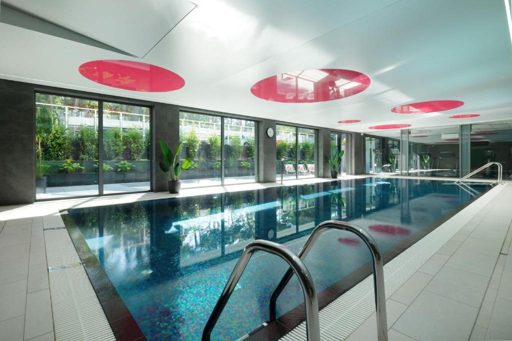 a large swimming pool in a building with windows at Gryf Ośrodek Pobierowo in Pobierowo