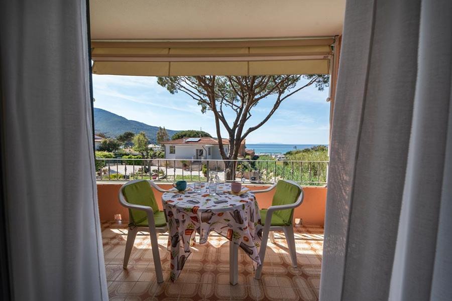 a table and chairs sitting on a balcony with a view at Villa Cecilia - Appartamenti in Procchio