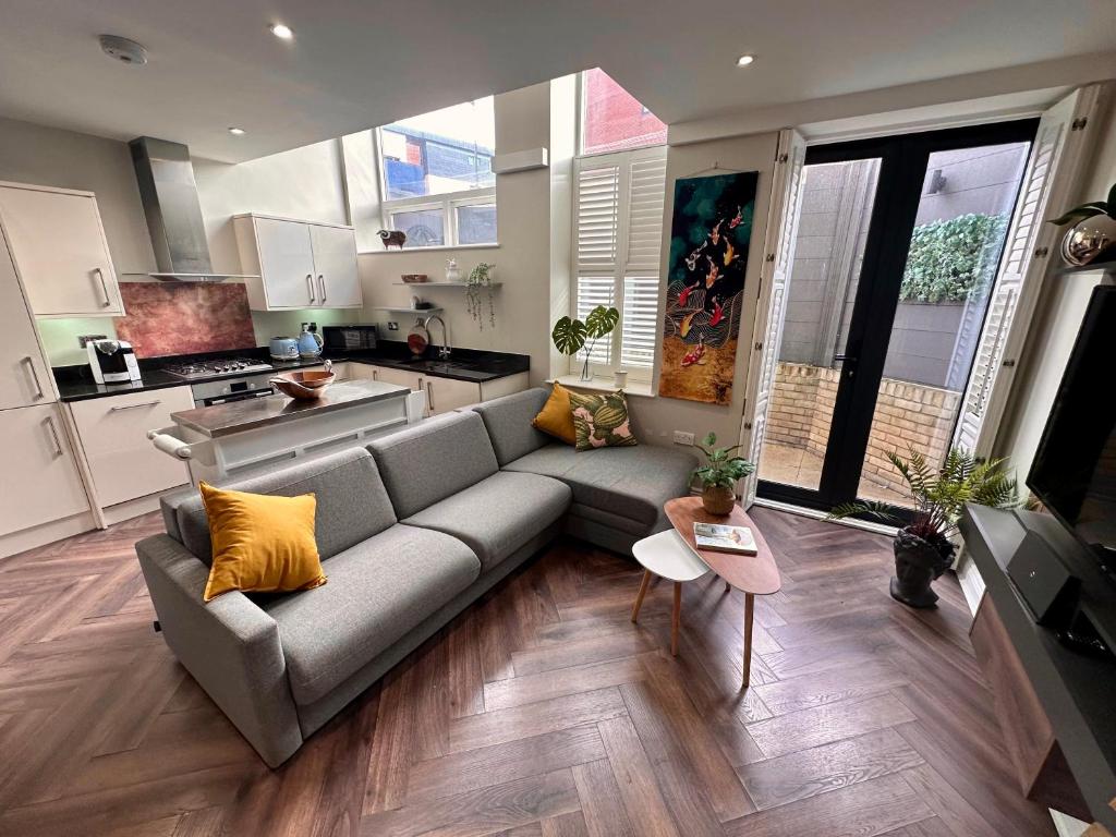 a living room with a couch and a kitchen at Stylish, modern appartment in Central London in London