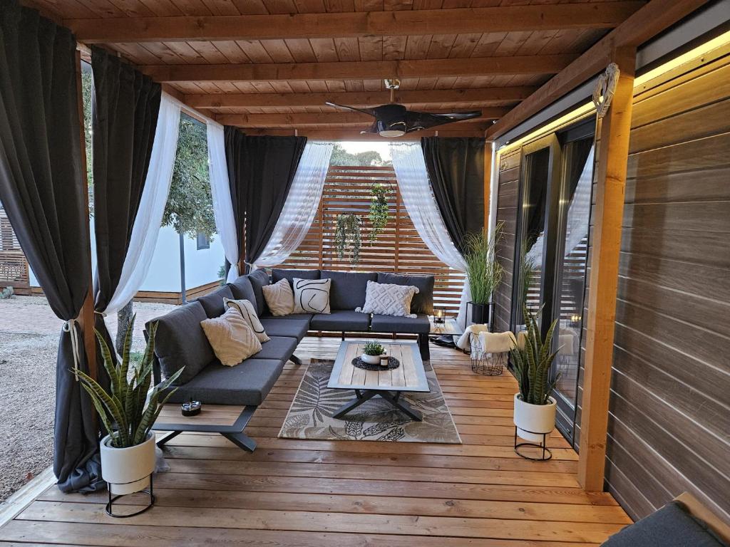 a screened in porch with a couch and a table at Mobile home My place in Biograd na Moru