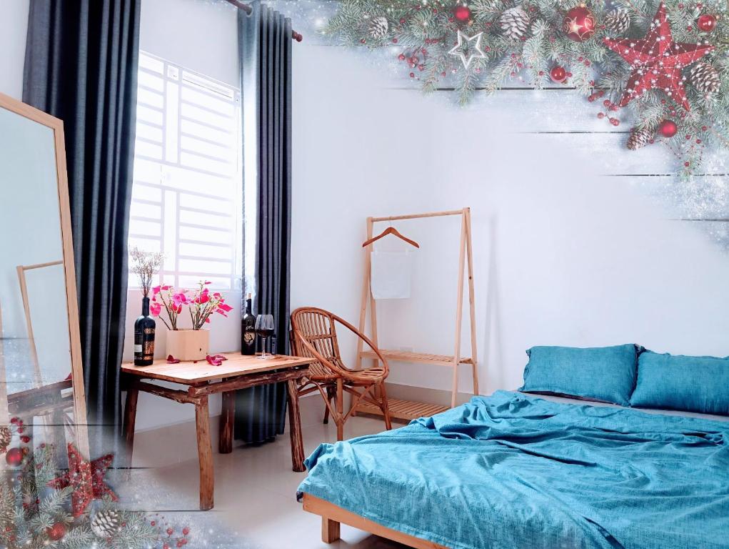 a bedroom with a bed and a table and a christmas tree at Adora Central Park Hostel in Can Tho