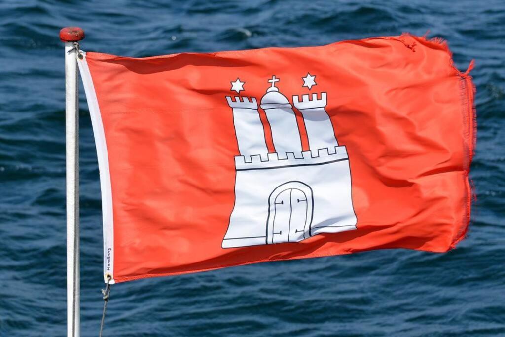 una bandera roja con un castillo sobre el agua en Apartment HH West modern und komfortabel, en Hamburgo