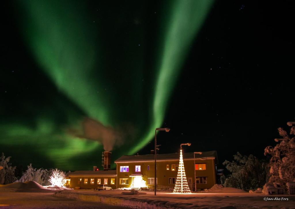 una imagen de la aurora en el cielo sobre un edificio en Lannavaara Lodge en Lannavaara