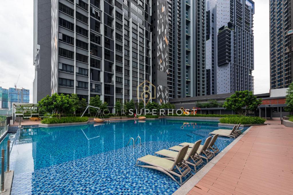a swimming pool with lounge chairs and buildings at Millerz Square Near MidValley by YourSuperhost in Kuala Lumpur