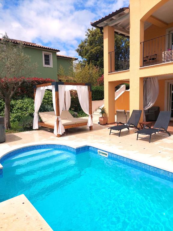 a swimming pool in front of a house at Villa Ari 8+2 in Krnica