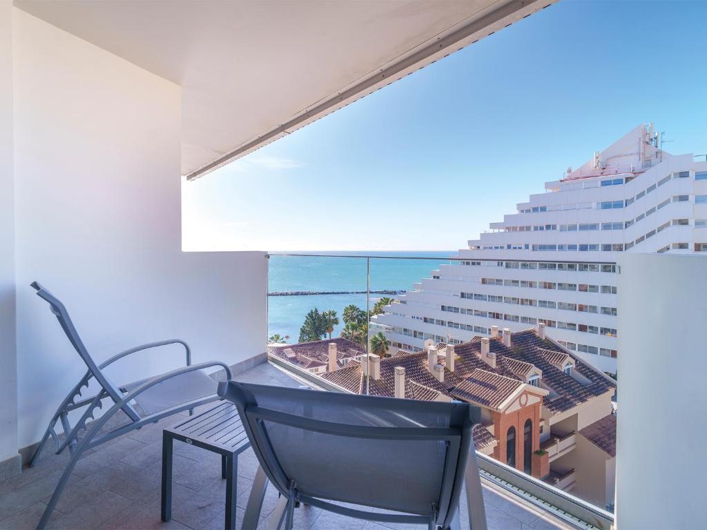 a balcony with chairs and a view of the ocean at Spirit Hotel Benalmadena Beach in Benalmádena