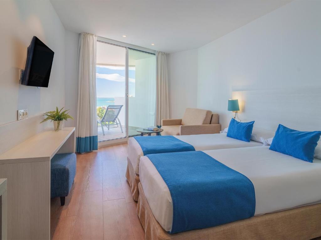 a hotel room with two beds and a television at Spirit Hotel Benalmadena Beach in Benalmádena
