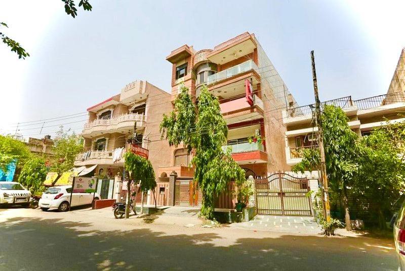 un edificio con coches estacionados frente a él en ASR Guest House, Janakpuri, New Delhi, en Nueva Delhi