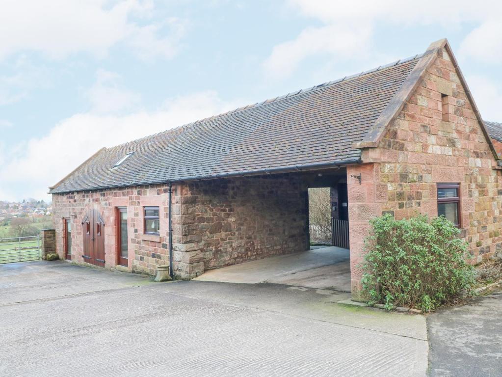 an old brick building with a large garage at Roaches View Barn in Stoke on Trent