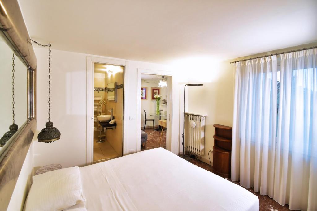 Perugia-Apartments Via della Gabbia في بيروجيا: غرفة نوم بسرير ابيض وحمام