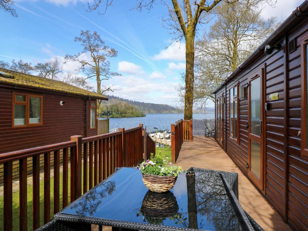 a table with a vase on top of a balcony at Shoreside Lodge in Bowness-on-Windermere