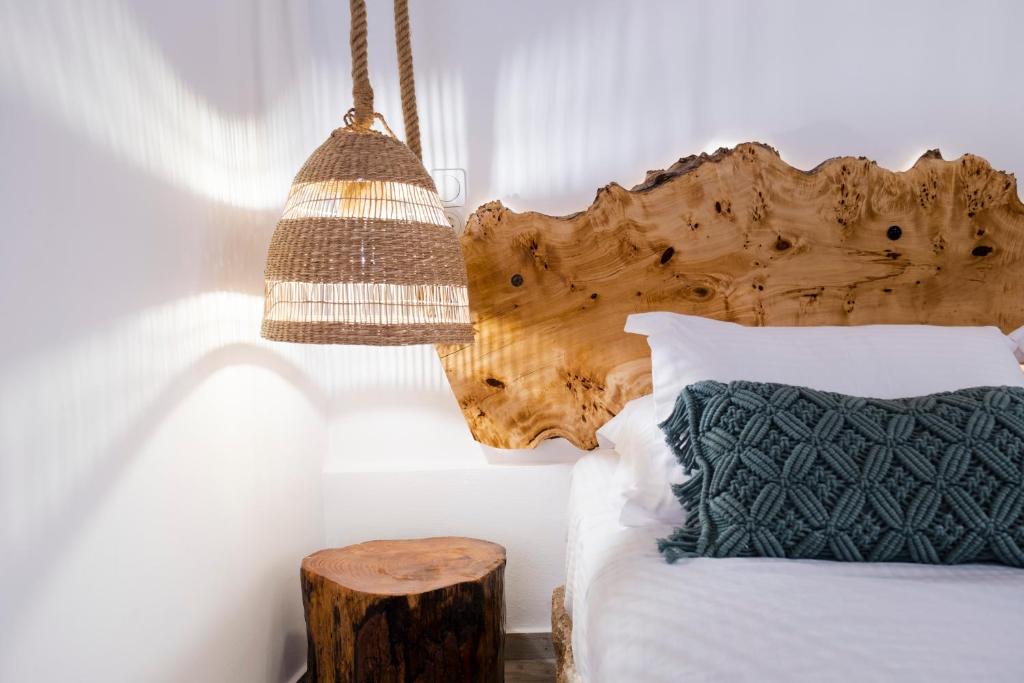 a bedroom with a bed with a wooden headboard and a lamp at ONAR LUXURIES in Ermoupoli