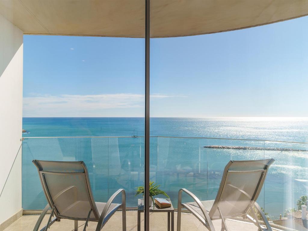 two chairs and a table with a view of the ocean at Spirit Hotel Benalmadena Beach in Benalmádena