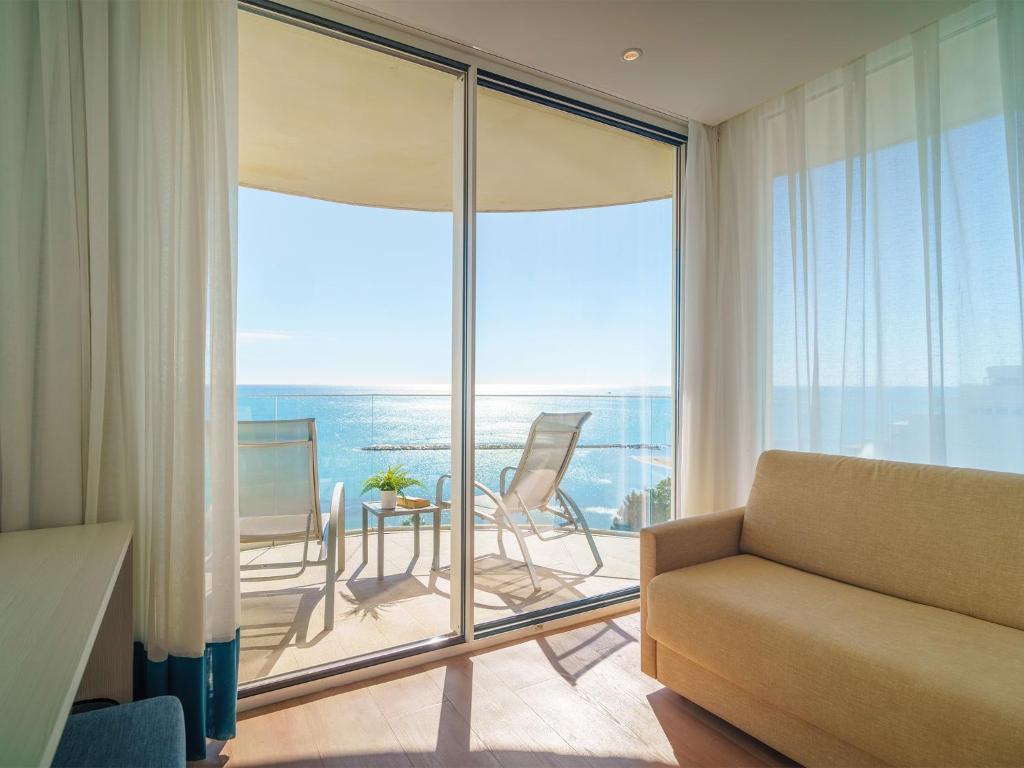 a living room with a couch and a view of the ocean at Spirit Hotel Benalmadena Beach in Benalmádena