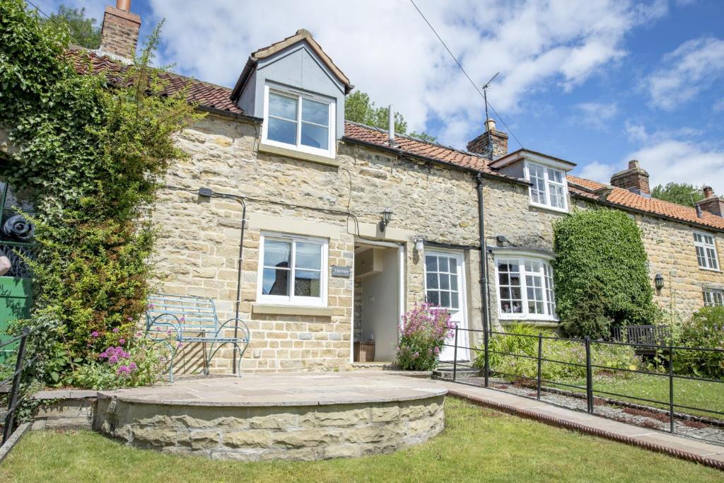 una casa de piedra con un círculo de piedra delante de ella en Fairview 2 en Ampleforth