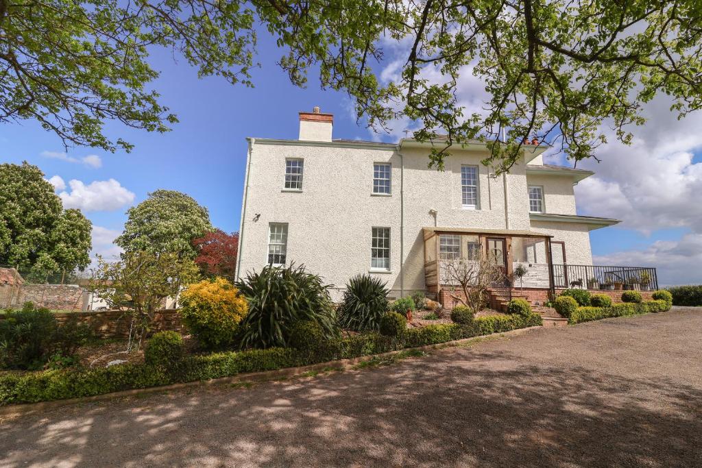 una imagen de una casa blanca con entrada en Buckland House en Taunton