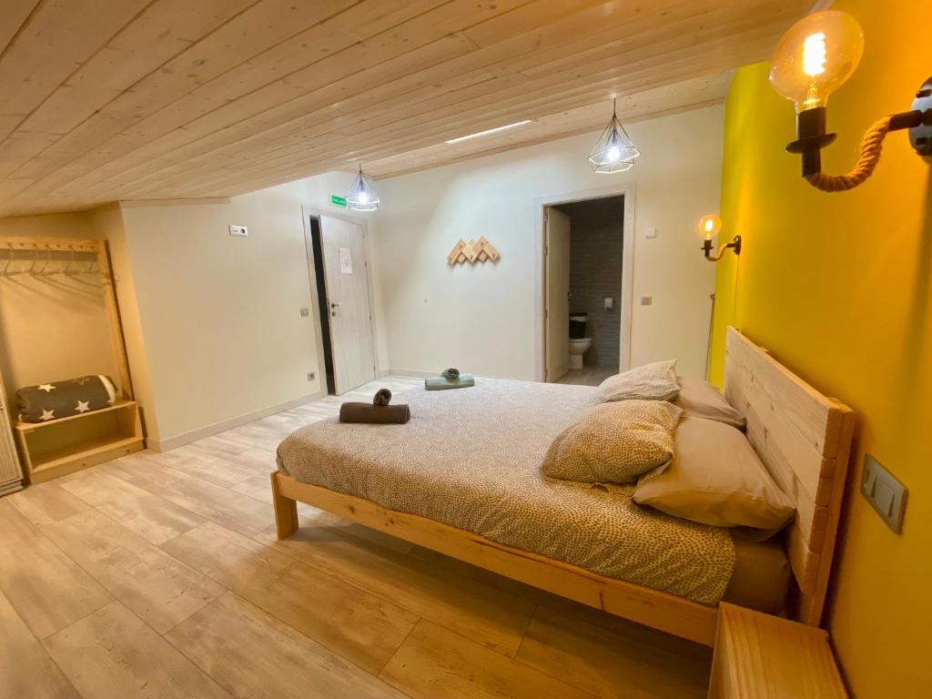 a bedroom with a bed and a yellow wall at Casa Julita Etxea in Morentin