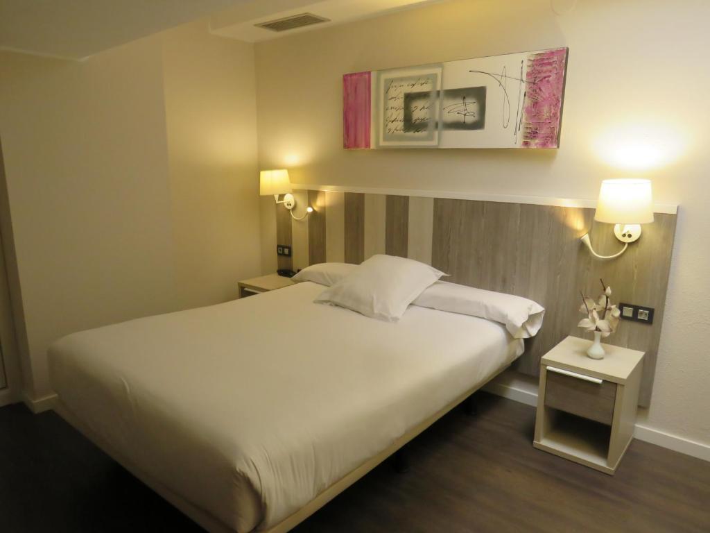 A bed or beds in a room at Hotel La Palma de Llanes
