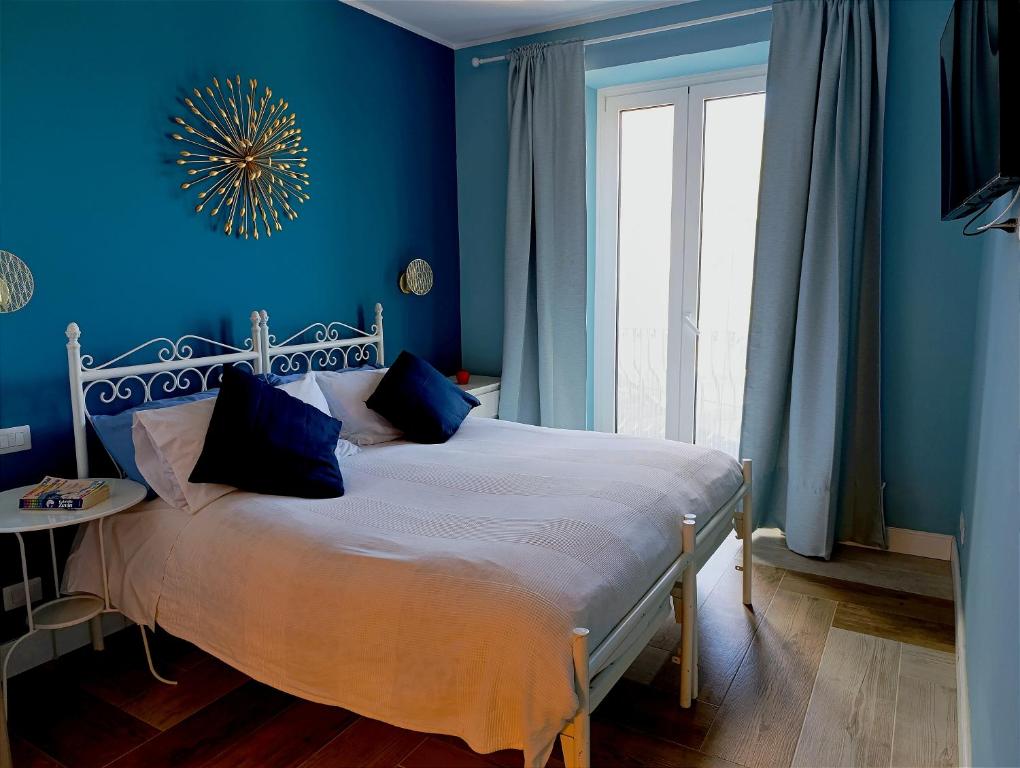 a blue bedroom with a bed with blue walls at Villino rosso in Taormina