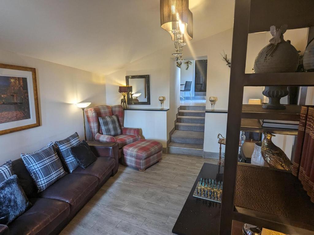 ein Wohnzimmer mit einem Sofa und einem Stuhl in der Unterkunft Charming 1-Bed Cottage on the outskirts of Haworth in Keighley