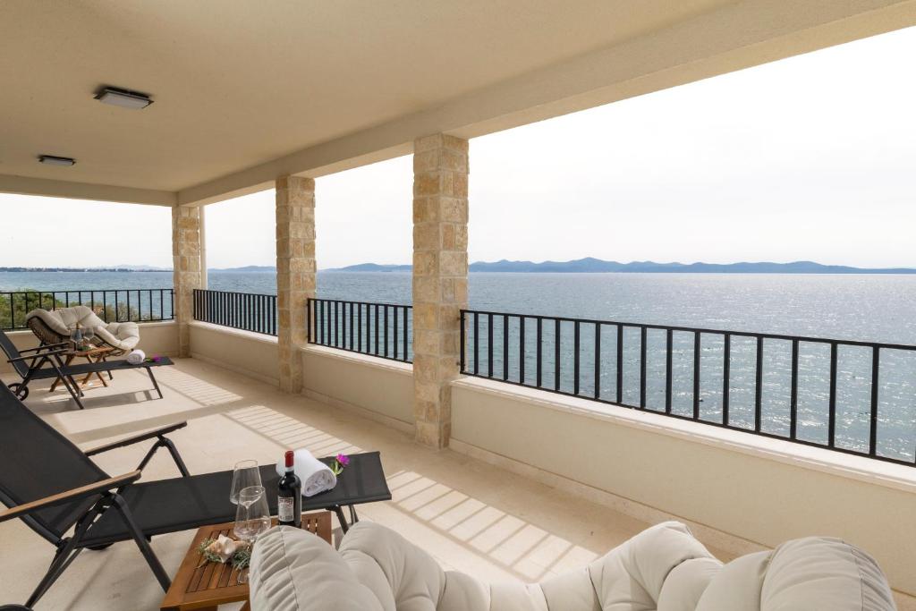 een balkon met uitzicht op het water bij Luxury beachfront villa in Kožino, Zadar with stunning sea views in Kožino