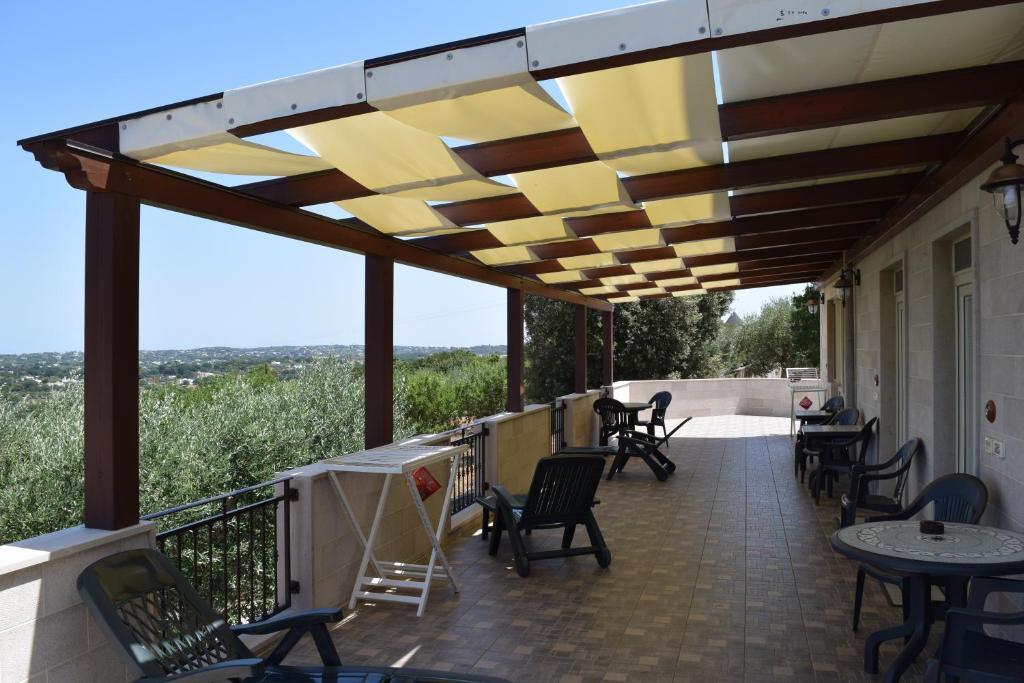 a patio with chairs and tables and awning at Bed & Breakfast La Collinetta in Locorotondo