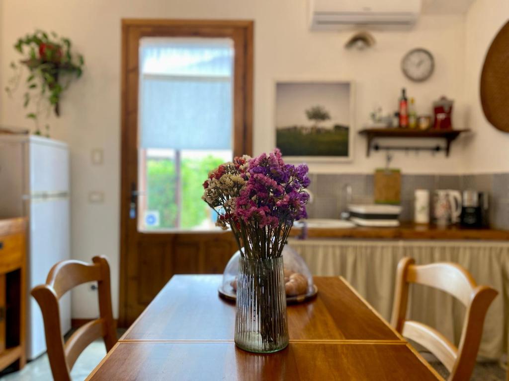 wazon kwiatów siedzący na stole w kuchni w obiekcie Stagnone Area Zero w mieście Birgi Vecchi