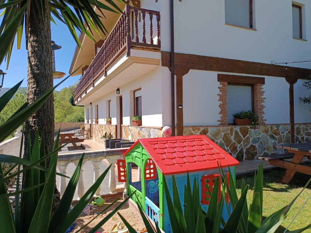 een speelhuis in de tuin van een huis bij Apartamentos la Escuela en Cantabria in Villegar