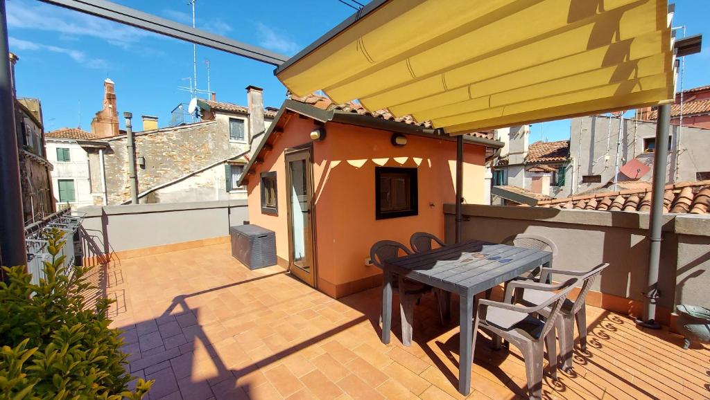 un patio con tavolo e sedie sul balcone. di Ca Rossa - Venezia a Venezia