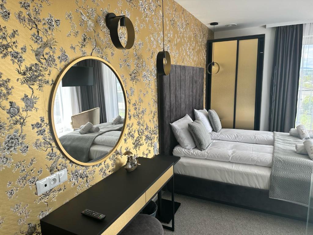een slaapkamer met een spiegel, een bed en een bank bij Złoty Szałas in Zarzecze