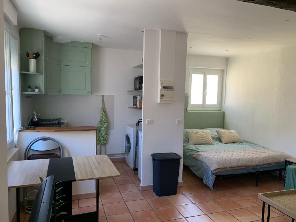 a small room with a bed and a kitchen at Studio cosy avec clim 33m2 in Aimargues