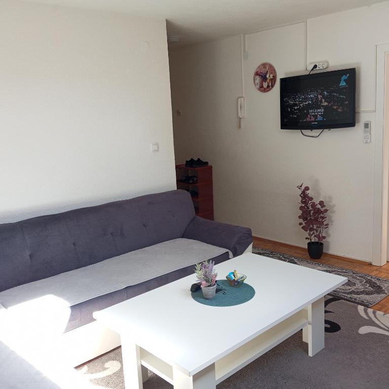 - un salon avec un canapé et une table dans l'établissement Cosy apartment, à Jajce